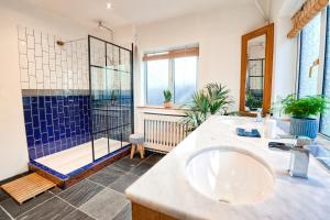 y baño con ducha, lavabo y bañera. en Spacious Sea-View Apt. Overlooking St Ives Bay, en Gwithian