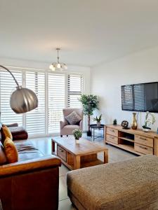 ein Wohnzimmer mit einem Sofa und einem Couchtisch in der Unterkunft Island Club by Smart City Stays in Kapstadt