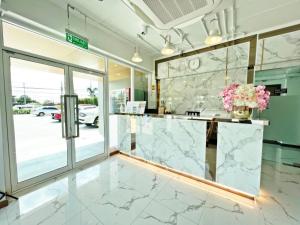 a marble counter in a lobby with a window at Golden Nest Hotel Suvarnabhumi in Bangkok