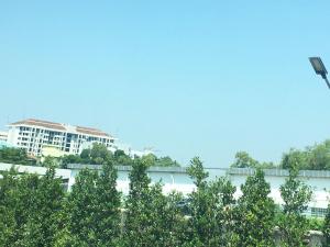 a building in the background with trees in the foreground at Golden Nest Hotel Suvarnabhumi in Bangkok