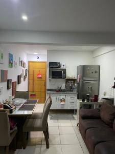 cocina y sala de estar con mesa y sofá en Loft completo próximo ao parque olímpico e 10 minutos da praia!, en Río de Janeiro