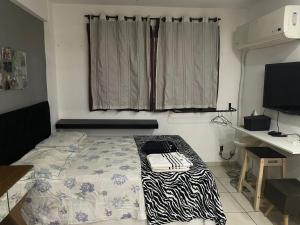 1 dormitorio con 1 cama con manta de cebra en Loft completo próximo ao parque olímpico e 10 minutos da praia!, en Río de Janeiro