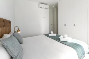 a bedroom with a white bed with towels on it at Swell House in Ferrel +23 photos