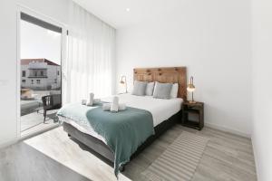 a white bedroom with a bed and a large window at Swell House in Ferrel