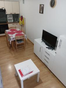 a living room with a table and a tv at VILLA DUCHATEL in Le Mont-Dore