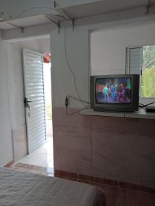 un televisor sentado en un mostrador en un dormitorio en Recanto das Videiras, en Maria da Fé