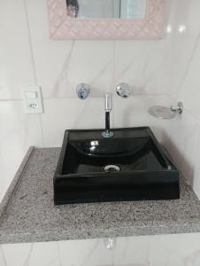 a black sink in a bathroom with a mirror at Recanto das Videiras in Maria da Fé +51 photos
