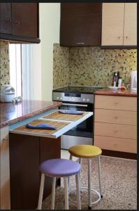 a kitchen with a stove and two stools at Kosmira Big House in Ioannina