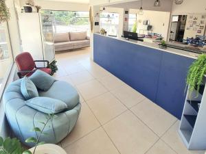 a waiting room with a blue couch and a counter at Acqua Flats Jaguariúna in Jaguariúna