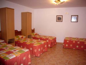 a room with four beds in a room at Alojamiento Rural Sierra de Gudar in Valbona