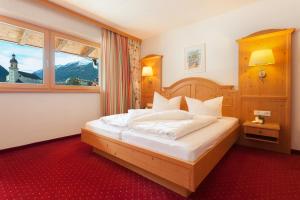 Schlafzimmer mit einem großen Bett und einem Fenster in der Unterkunft Hotel Augarten in Neustift im Stubaital