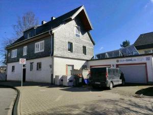 uma casa com uma carrinha estacionada em frente em Loft mit großer Terrasse bei der Kinderklinik 2C em Siegen