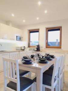 a kitchen with a table with plates and glasses on it at Domki Na Wzgórzu Woda JACUZZI SAUNA ROWERY in Zawóz