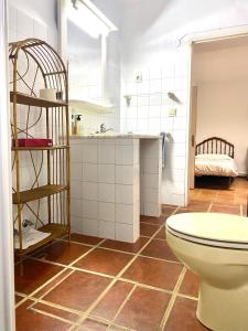 y baño con aseo en el suelo de baldosa. en Las maravillas de Manuel By Solymar Holiday, en Málaga
