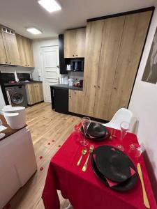 een rode tafel met borden en glazen erop in een keuken bij Love Room à Cannes - Appartement 25m2 pour 2 personnes avec un jacuzzi Privé in Cannes