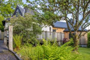 Appin的住宿－Kinlochlaich Tree House，庭院中带木栅栏的房子