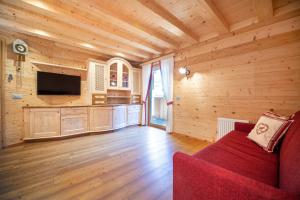 een woonkamer met een rode bank en een televisie bij Apartments Bea in Ortisei