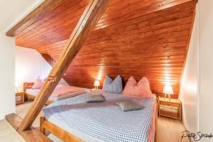 1 dormitorio con 1 cama con pared de madera en Roubenka Výletní, en Desná