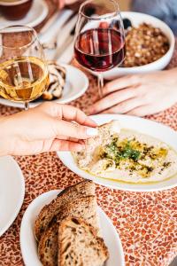 a table with plates of food and glasses of wine at Hôtel Voltaire in Arles