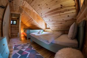 a bedroom with a bed in a wooden room at Vilovi Botić in Nova Varoš