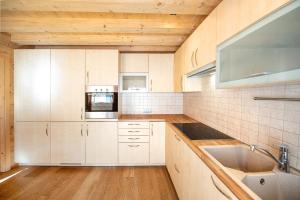 a kitchen with white cabinets and a sink at Apartments Bea in Ortisei