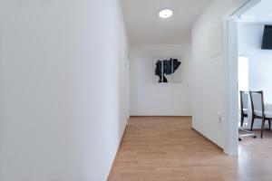 a hallway with white walls and a table and chairs at Stella Boutique Rooms in Sesvete