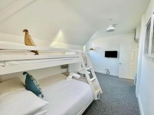 a bedroom with two bunk beds and a tv at Four Oaks in Bournemouth