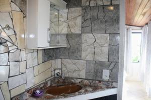 ein Bad mit einem Waschbecken und einem Spiegel in der Unterkunft Apartamento moderno con vista reserva ecológica in Búzios