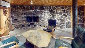 a stone room with a chair and a stone fireplace at Katasijan Villa in Salla