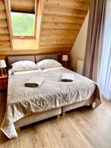 a bedroom with a bed with two towels on it at Gościniec w Zakopanem in Zakopane