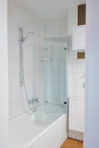 een badkamer met een douche en een bad bij Zentrale & gemütliche 3-Zimmer-Wohnung, mit Netflix & Sky, in der Nähe von Uni, Klinikum & Zentrum, mit Stellplatz in Kassel