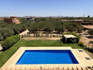 a large blue swimming pool in the middle of a yard at Luxury villa with a pool for your family getaway in Marrakesh