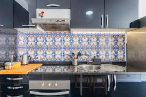 a kitchen with a sink and blue tiles on the wall at Apartamento Lar doce Lar Porto in Vila Nova de Gaia
