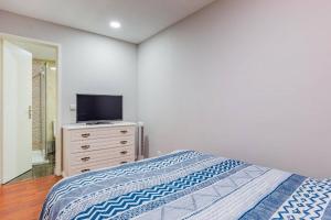 a bedroom with a bed and a television on a dresser at Apartamento Lar doce Lar Porto in Vila Nova de Gaia