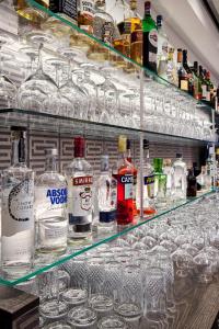 a shelf filled with glasses and bottles of alcohol at Keizershof Hotel Aalst in Aalst