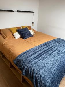a bed with a blue blanket and pillows on it at Antwerpcityhome in Antwerp