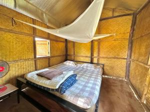 a bed in a small room with a mosquito net at Twin Hut in Pai