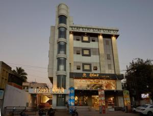 a building with a tower with a store in front of it at Hotel Rose Gold in Ahmadnagar