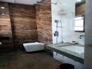 艾哈邁德納格爾的住宿－Hotel Rose Gold，带浴缸、卫生间和盥洗盆的浴室