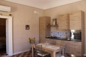 Notobarocco في نوتو: مطبخ مع طاولة وكراسي في الغرفة