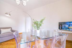 uma sala de estar com uma mesa de vidro e um sofá em Penthouse in the heart of the city center em Roma