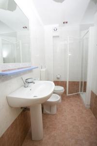 biała łazienka z umywalką i toaletą w obiekcie Long Beach Village Residence sul mare spiaggia privata inclusa w mieście Lido Adriano