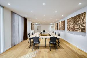 a conference room with a long table and chairs at Keizershof Hotel Aalst in Aalst