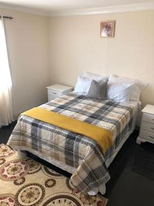 ein Schlafzimmer mit einem Bett mit einer Decke und einem Teppich in der Unterkunft 2bed apt with 24hr Security* in Kingston