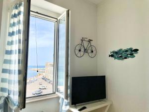 a room with a window with a bike on the wall at CASA ROSITA-vista cattedrale,mare,tribunale e castello nel pieno CENTRO di Trani-WIFI in Trani