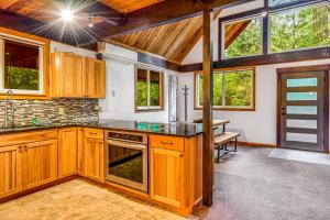 a kitchen with wooden cabinets and a table and windows at Alderbrook A-Frame in Union