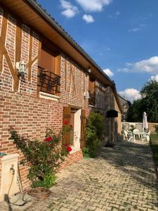 ceglany budynek z drzwiami i patio w obiekcie chambre salon indépendant, salle de bain wc privés, jardin privé, piscine partagée près d'un lac w mieście Mesnil-Saint-Père