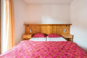 a bedroom with a large bed with a purple blanket at Delizioso appartamento trilocale a Moena in Moena