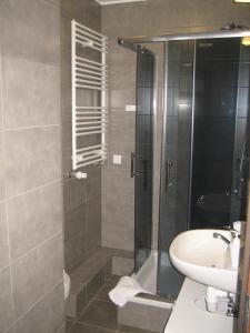 La salle de bains est pourvue d'une douche et d'un lavabo. dans l'établissement Apartamenty Sedinum - Bryza, à Szczecin