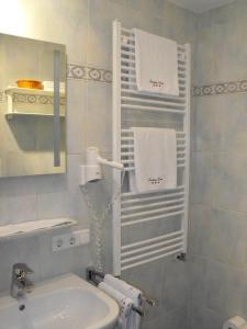 a bathroom with a sink and a mirror and towels at Landhaus Degen in Bischofswiesen
